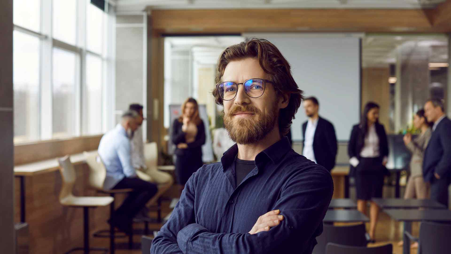 Un leader d'une PME se tient fièrement debout suite à un coaching en leadership avec son équipe